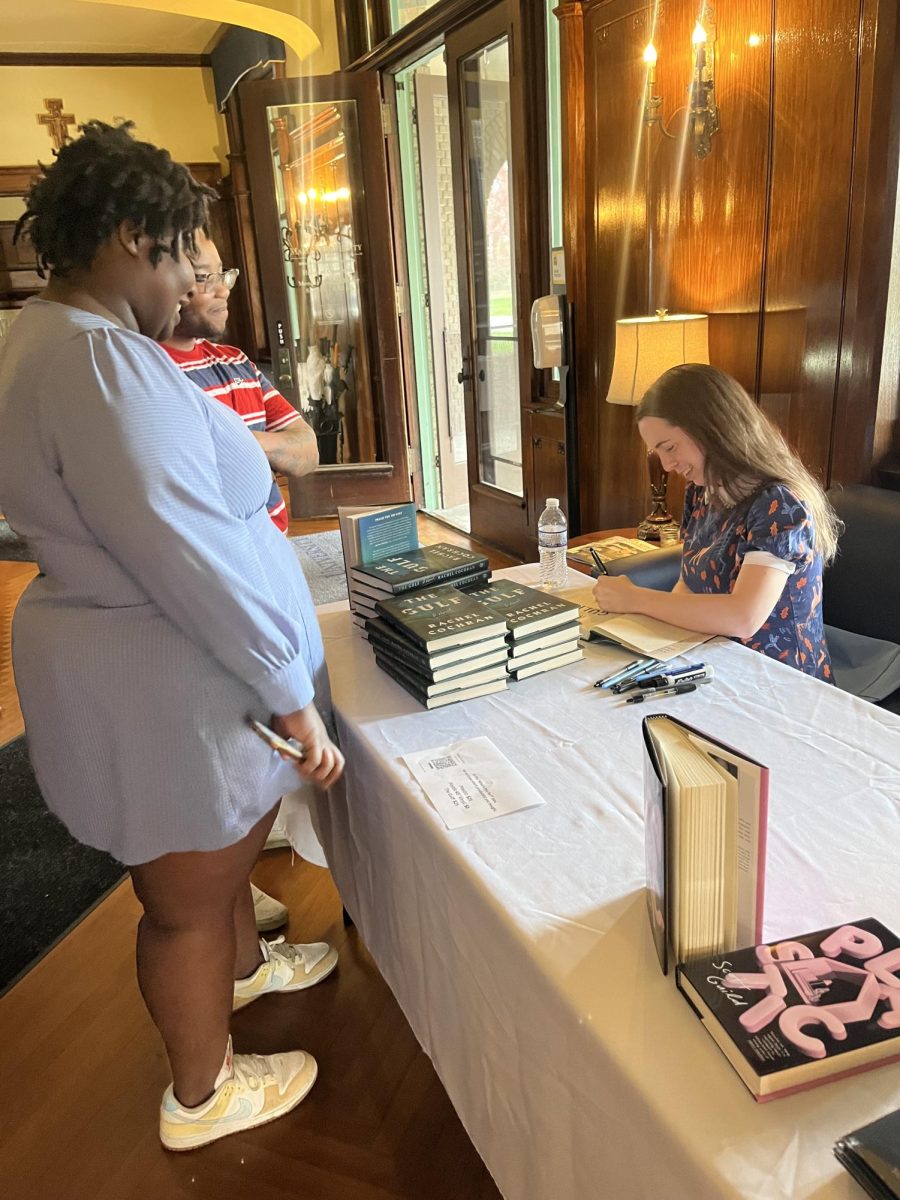 Dr. Rachel Cochran signing a copy of her novel, The Gulf, for a student. 